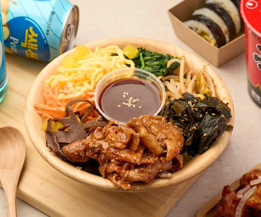 台北飯捲辣炒豬肉拌飯搭配紅醬豬肉片與蔬菜裝盤